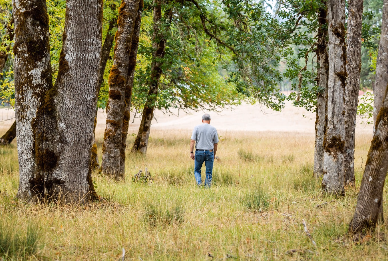 Person walking Southern Oregon oak meadow property — seller representation by Aaron Cherry Real Estate, Roseburg, Douglas County